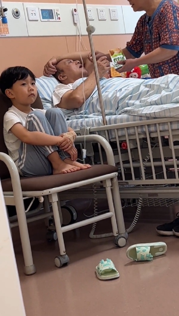  Khuôn mặt "bất lực" của cậu bé khi chứng kiến cảnh bà chăm sóc ông vô cùng chu đáo.&nbsp;(Ảnh: Cắt từ Douyin yu_xiaoyu2015)