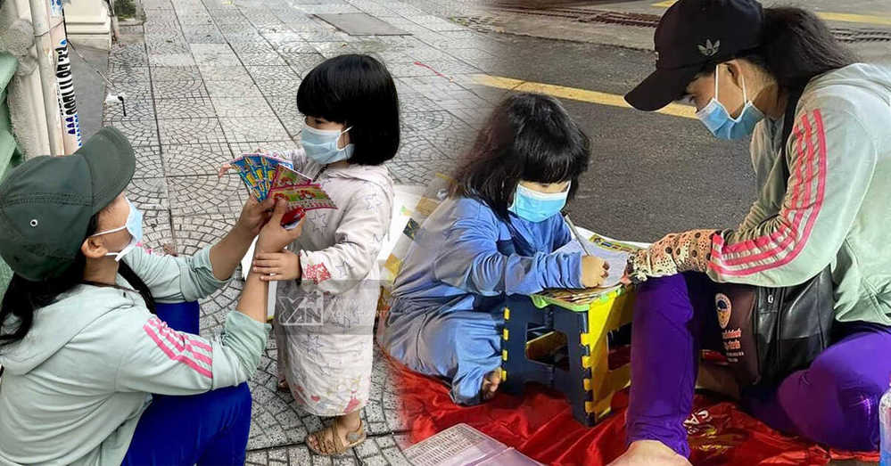  Mẹ dạy con viết chữ giữa phố với vật dụng cực kì đơn sơ. (Ảnh: Fanpage S.G.N)