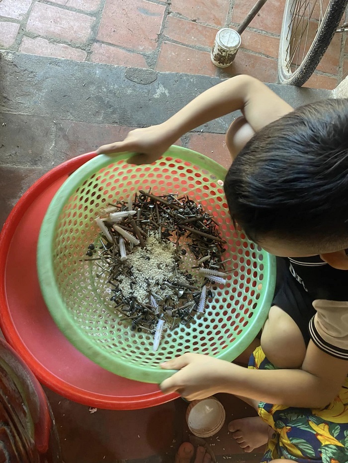  Hai cậu con trai được mẹ hướng dẫn sàng gạo.&nbsp;(Ảnh: FB T.N.N)