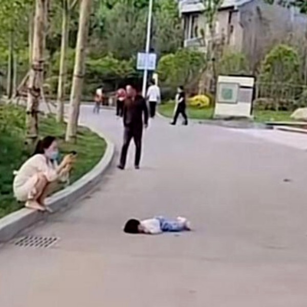  Bé gái kiên quyết không đứng dậy mặc cho người mẹ đã thử dỗ dành. (Ảnh: Sohu)