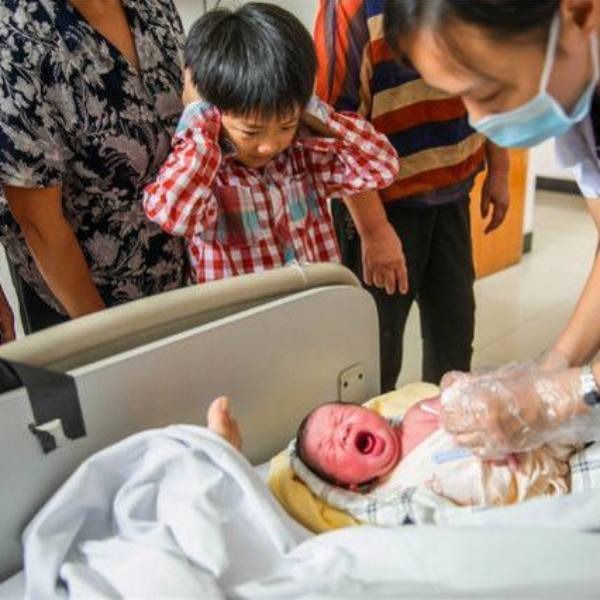  Dù rất hạnh phúc nhưng cậu bé cũng không tránh khỏi bất ngờ vì tiếng khóc của em gái. (Ảnh: KKnews)