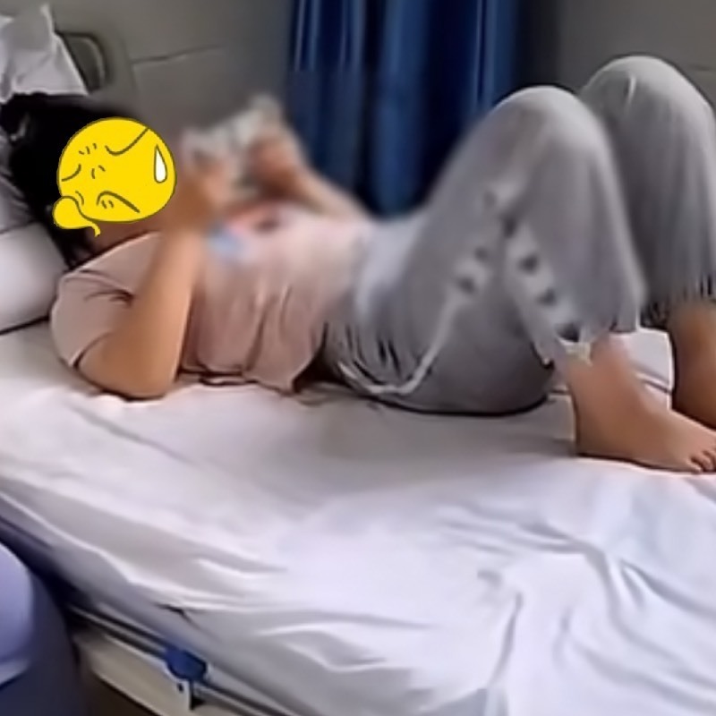  Cô cháu gái nằm trên giường thản nhiên chơi điện thoại không để ý đến ông. (Ảnh: Chụp màn hình Sina)