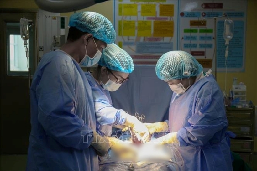 Các bác sĩ tiến hành phẫu thuật cho người bệnh. Ảnh: TTXVN