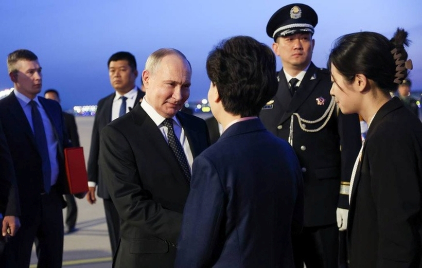 Tổng thống Nga Vladimir Putin bắt tay Ủy viên Quốc vụ viện Thầm Di Cầm sau khi đến Trung Quốc. Ảnh: TASS