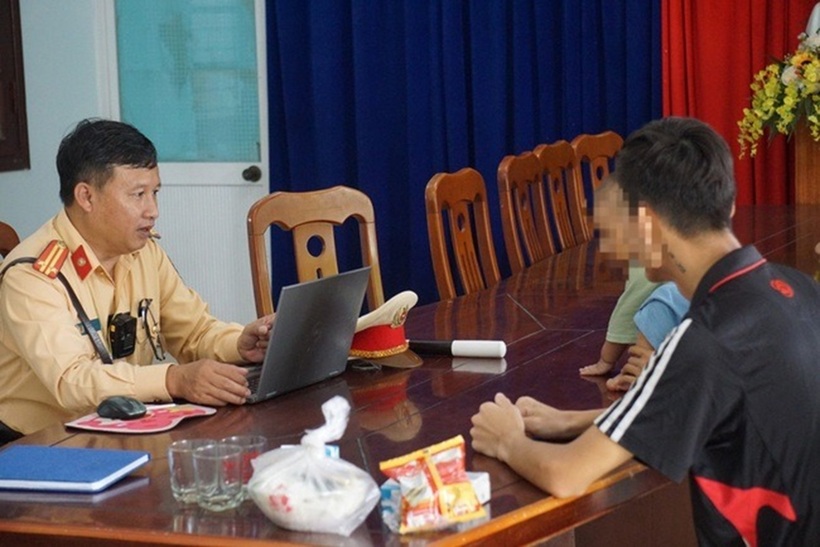 Trung tá Lê Phước Ngãi, Phó trạm trưởng Trạm CSGT Cửa ô Hòa Hiệp hỏi thăm về hoàn cảnh của gia đình anh Duy. Ảnh: Báo Giao thông