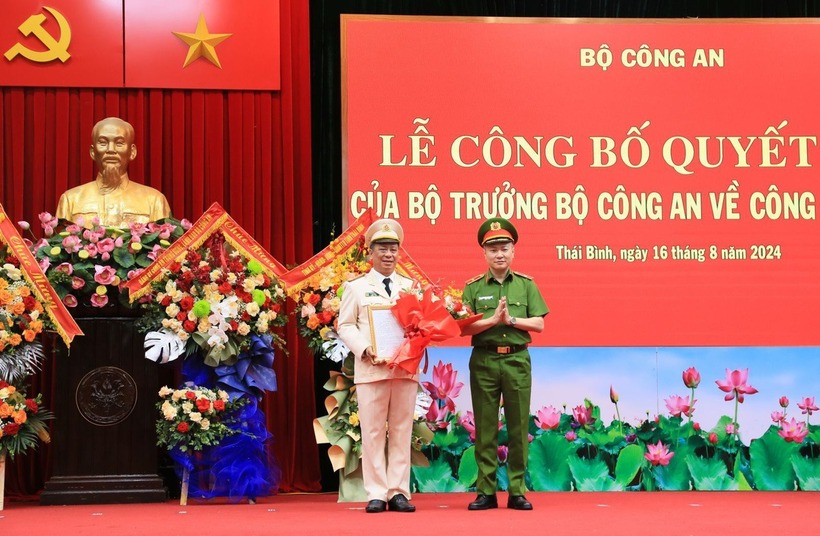 Thiếu tướng Nguyễn Ngọc Lâm, thứ trưởng Bộ Công an, trao quyết định và tặng hoa chúc mừng Đại tá Trần Xuân Ánh. Ảnh: Tuổi Trẻ