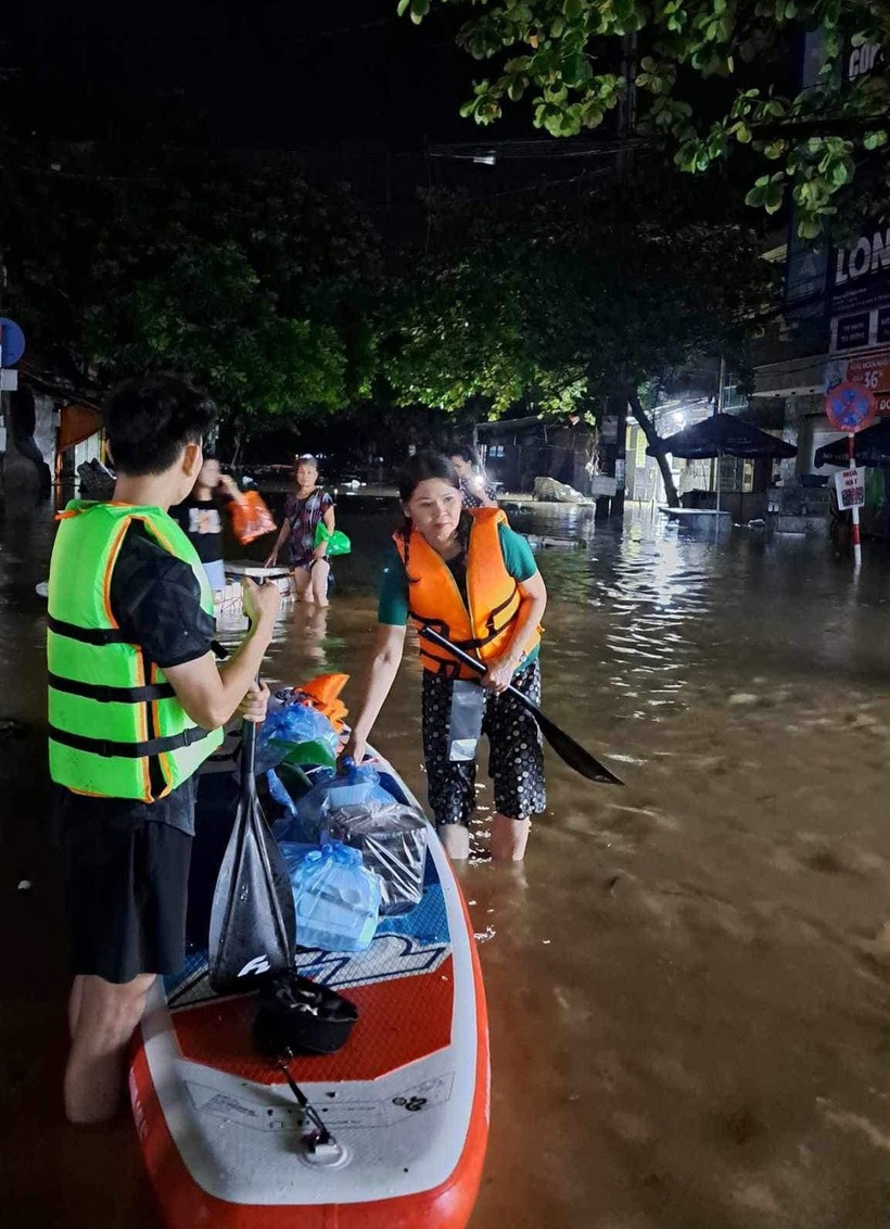 Bà Trần Kim Hà chèo sup mang cơm hộp cho những hộ dân bị cô lập. Ảnh: Tuổi Trẻ