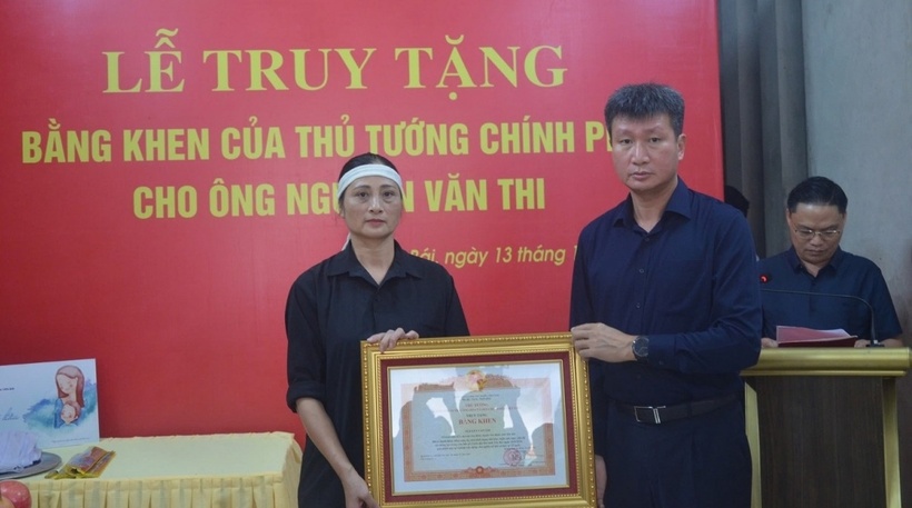 Ông Trần Huy Tuấn, Chủ tịch UBND tỉnh Yên Bái trao bằng khen của Thủ tướng Chính phủ cho thân nhân ông Nguyễn Văn Thi. (Ảnh: VOV)