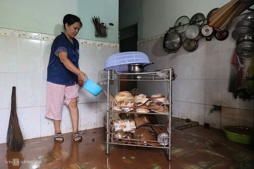 Người dân tranh thủ dọn dẹp khi nước lũ rút. Ảnh: VnExpress