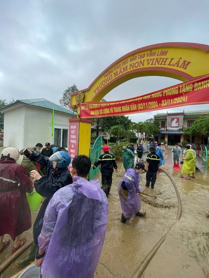 Công an Quảng Trị nỗ lực hỗ trợ các trường học trên địa bàn thu dọn lớp bùn non để lại ngay khi lũ rút. (Ảnh: SGGP)
