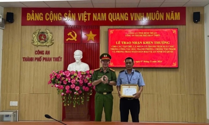 Thượng tá Trần Long Khánh, Trưởng Công an TP Phan Thiết trao thưởng cho anh Nguyễn Công Định. (Ảnh: PLO)