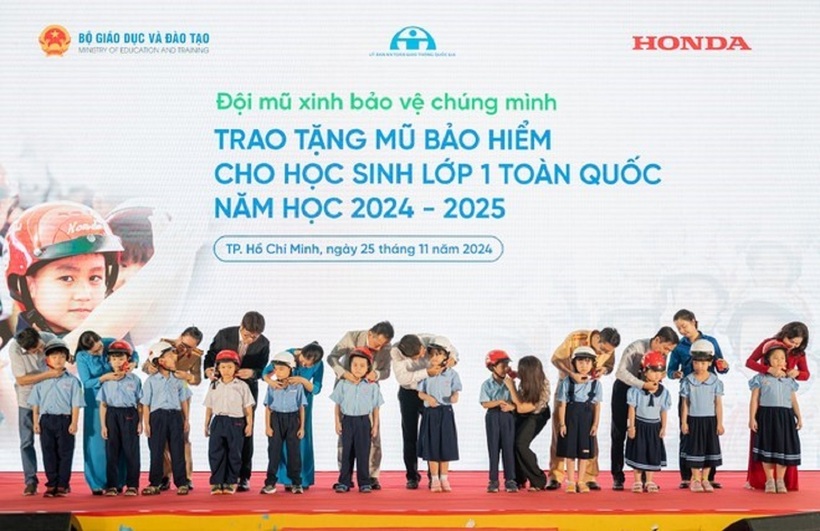 Các đại biểu trao tặng mũ bảo hiểm cho các em học sinh lớp Một trường Tiểu học Giồng Ông Tố, TP Thủ Đức (TP.HCM)