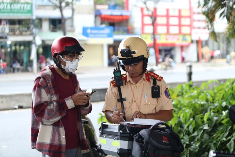 Anh T. vi phạm hành vi vượt đèn đỏ bị cảnh sát giao thông lập biên bản. (Ảnh: Tuổi trẻ)