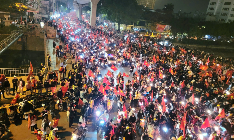 Trên đường Cầu Giấy – Hà Nội, người hâm mộ nô nức hò reo, giương cao lá cờ tổ quốc đầy tự hào.