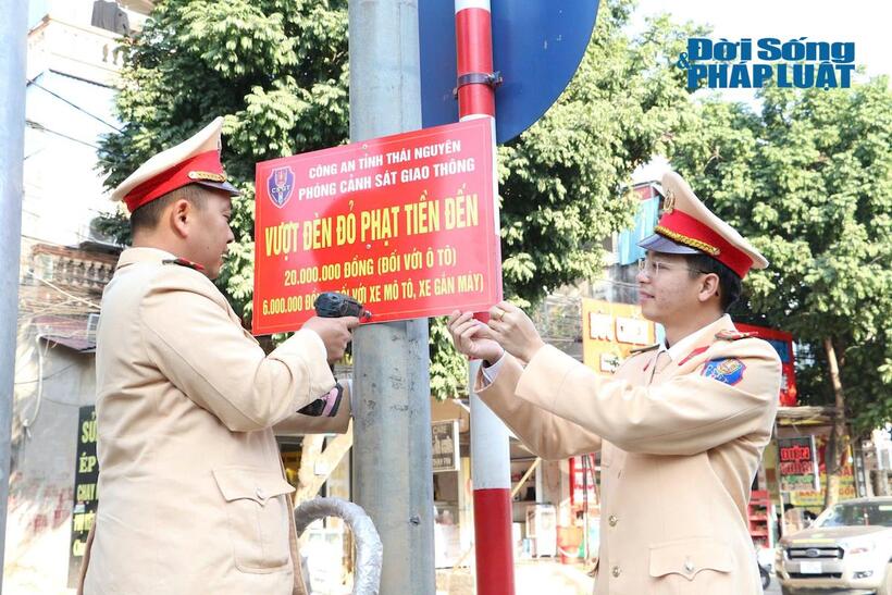 Cán bộ Phòng CSGT gắn biển tuyên truyền quy định xử phạt