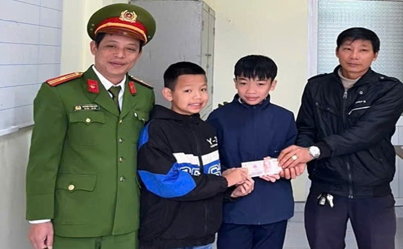 Em Nguyễn Lê Hoàng và Trần Xuân Anh trả lại tài sản cho người đánh rơi. (Ảnh: CAND)