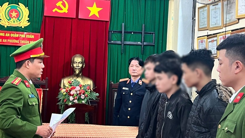 Lực lượng chức năng đọc quyết định khởi tố, bắt tạm giam nhóm thanh thiếu niên. Ảnh: Báo Công lý