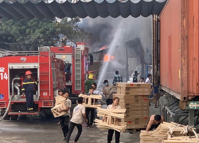 Công nhân vận chuyển tài sản ra ngoài. (Ảnh: VNE)