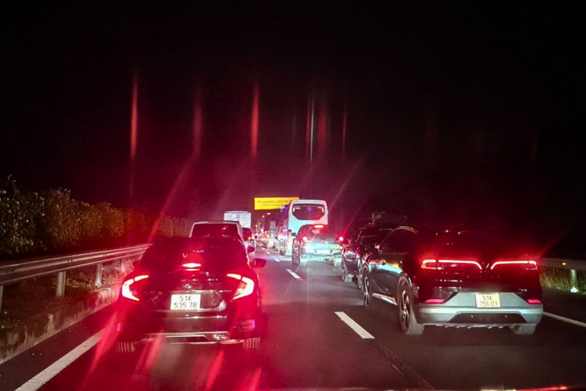 Các xe di chuyển chậm trên cao tốc do sự cố cháy xe container. Ảnh: VietNamNet