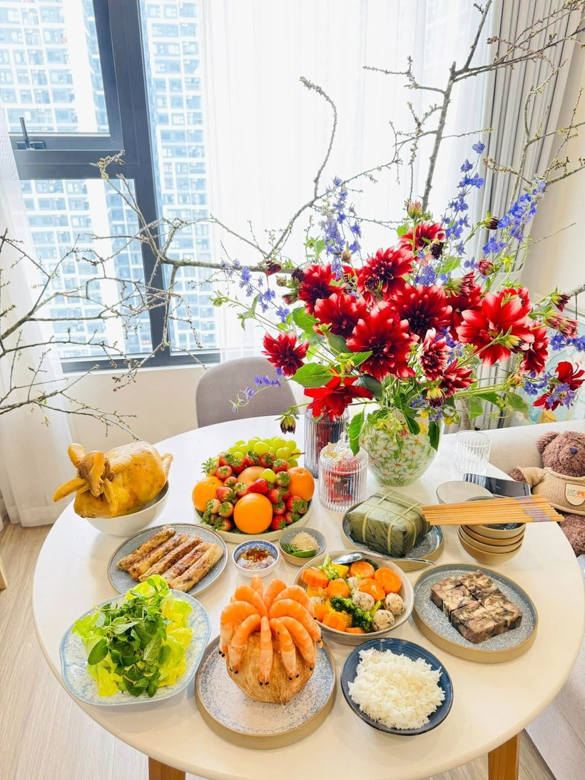 Mâm cỗ cúng gồm các món gà luộc, bánh chưng, nộm bò khô, cá lăng nướng, giò lụa, xôi gấc, canh măng, canh miến, bánh bao kim tiền, cơm trắng, hoa quả.