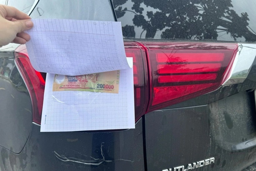 Tờ tiền mệnh giá 200.000 đồng dán mặt sau mảnh giấy. Ảnh: Báo Dân trí.