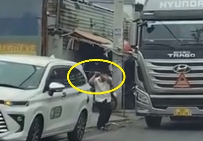 Hình ảnh tài xế taxi cầm gậy sắt đập phá xe tải. Ảnh: Công An Nhân Dân