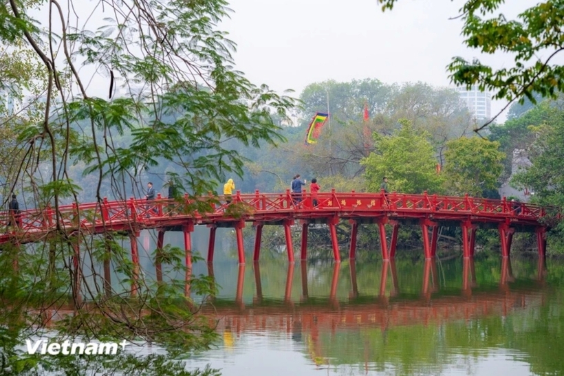 Khung cảnh yên bình tại Hồ Gươm, những ánh nắng đầu tiên của năm mới phản chiếu hình bóng của cầu Thê Húc và đền Ngọc Sơn.