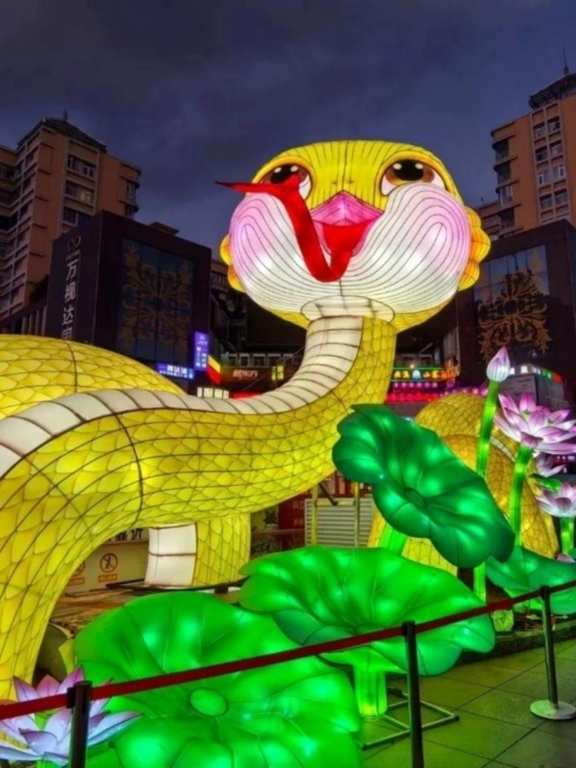 Linh vật rắn trên tuyến phố đi bộ Nam Bình (TP.Côn Minh, tỉnh Vân Nam, Trung Quốc) sở hữu vẻ ngoài độc lạ. Đó là chiếc đèn lồng mô phỏng linh vật hình rắn với chiếc đầu tròn màu vàng, lưỡi thè dài kèm theo nụ cười ngô nghê. Lá sen và một số chi tiết tiểu cảnh được trang trí phía dưới.