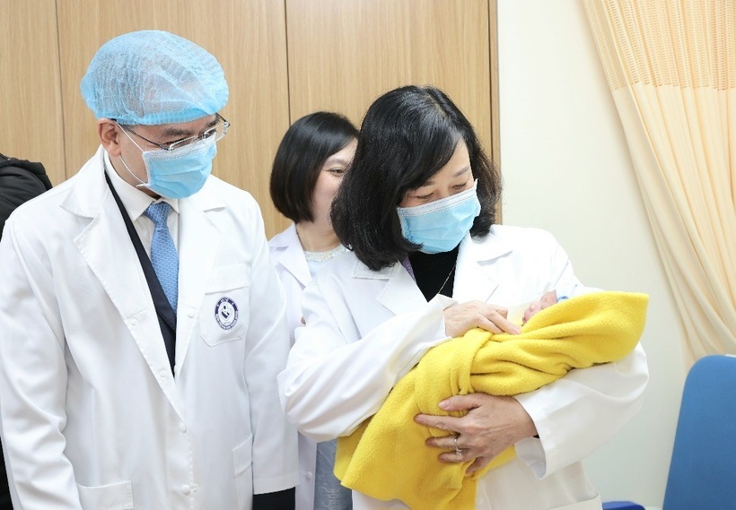Bộ trưởng Bộ Y tế Đào Hồng Lan bế em bé chào đời trong đêm Giao thừa Tết Ất Tỵ tại Bệnh viện Phụ sản Trung ương. Ảnh: Sức khỏe và Đời sống