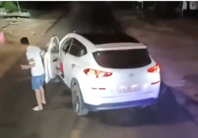 Thanh niên đậu xe ô tô giữa đường, gây mất an toàn giao thông. Ảnh: Lao Động