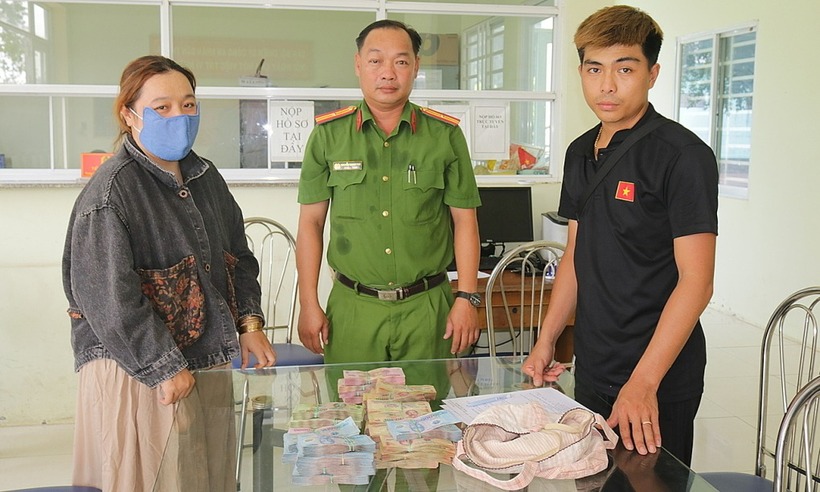 Chị Hằng trao trả số tiền cho người đánh rơi tại công an phường. (Ảnh: VNE)