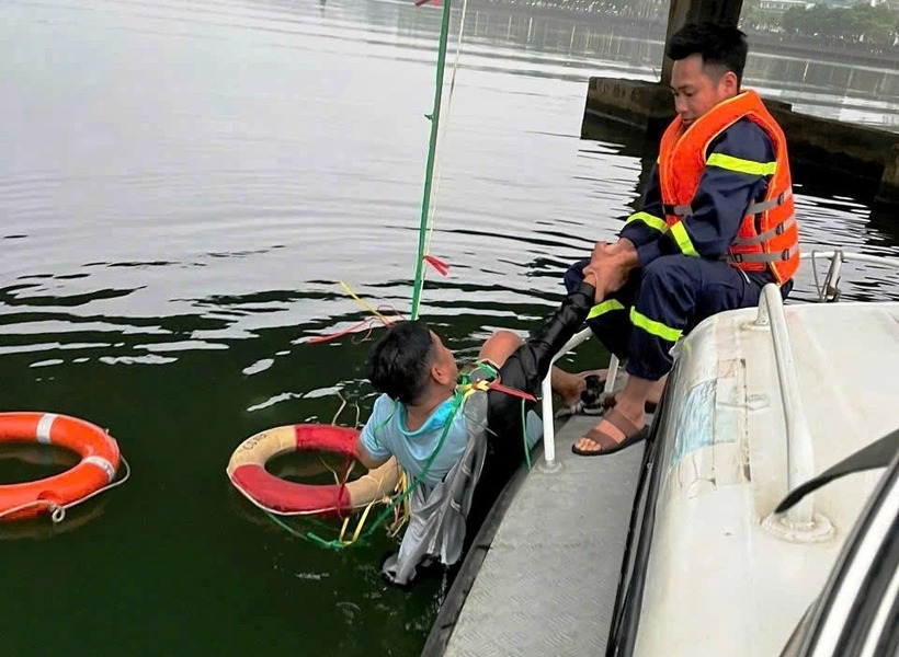 Lực lượng công an nỗ lực đưa người đàn ông lên bờ sau khi nạn nhân nhảy xuống sông Hương tự tử. (Ảnh: Tiền phong)