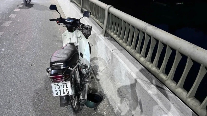 Chiếc xe máy, mũ bảo hiểm để lại trên cầu. Ảnh: Pháp luật TP.HCM.