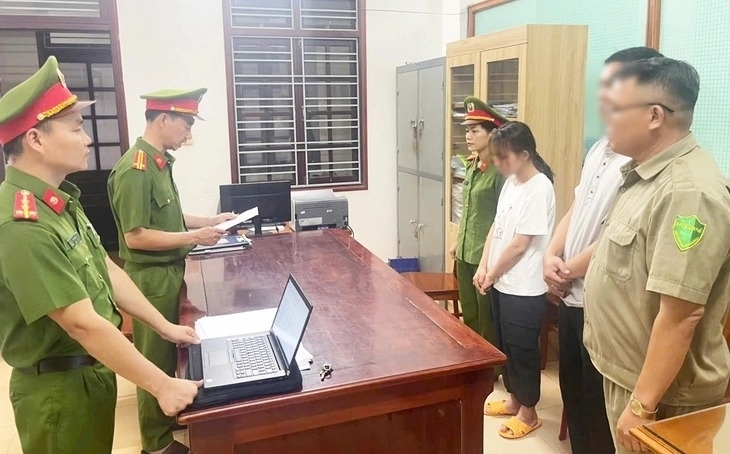 Công an đọc quyết định giữ người đối với bà L. Ảnh: Tuổi trẻ