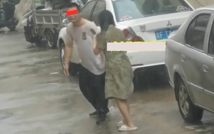 Cả hai cùng đứng dưới những cơn mưa, ôm nhau khóc. Ảnh: Sohu.
