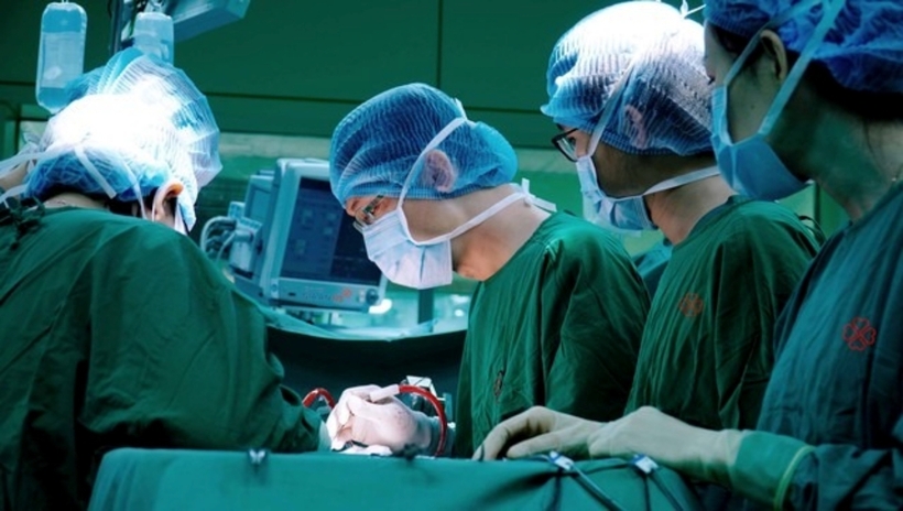 Các bác sĩ tiến hành phẫu thuật cho người đàn ông. Ảnh: Người Lao Động