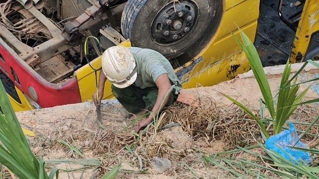 Người thân đang lật tung từng ngọn cỏ tại hiện trường để tìm ngón tay cho nữ sinh P.N.Q. (Ảnh: Người lao động)
