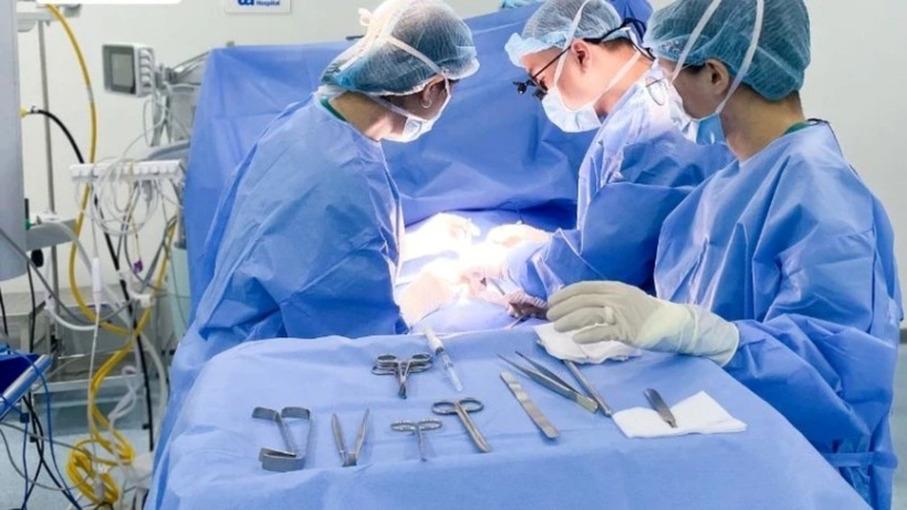 Êkíp bác sĩ phẫu thuật cho bệnh nhi. Ảnh: Báo Nhân Dân.