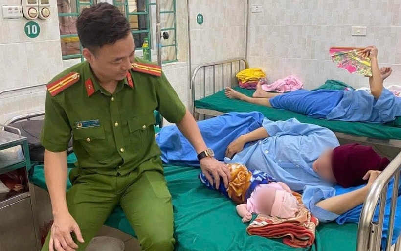 Thiếu tá Đặng Ngọc Cường đến bệnh viện thăm và tặng quà 2 mẹ con sản phụ. Ảnh: Phụ Nữ Việt Nam