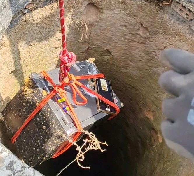 Chiếc két sắt được đưa lên miệng giếng và bàn giao cho cơ quan chức năng. (Ảnh: Công an tỉnh Kon Tum)