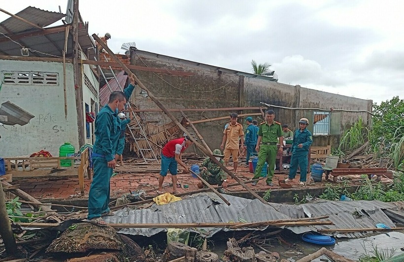 Lực lượng chức năng hỗ trợ người dân dọn dẹp sau lốc xoáy. (Ảnh: VNE)