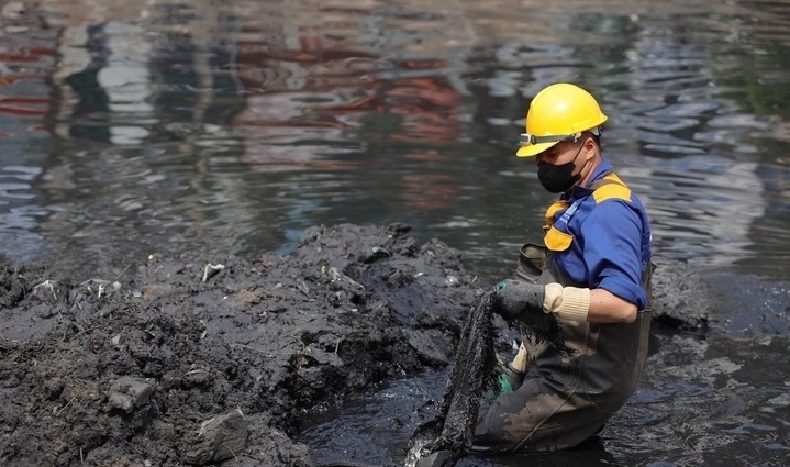 Công nhân thoát nước hút bùn, nạo vét tổng thể sông Tô Lịch giai đoạn 1. (Ảnh: Tuổi trẻ)