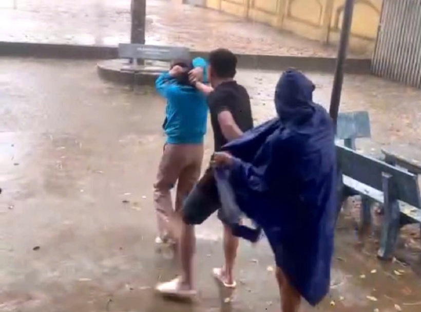 Mặc dù có người can ngăn nhưng người đàn ông vẫn tiếp tục túm tóc cô giáo đưa ra ngoài sân. Ảnh: Sức khỏe & Đời sống