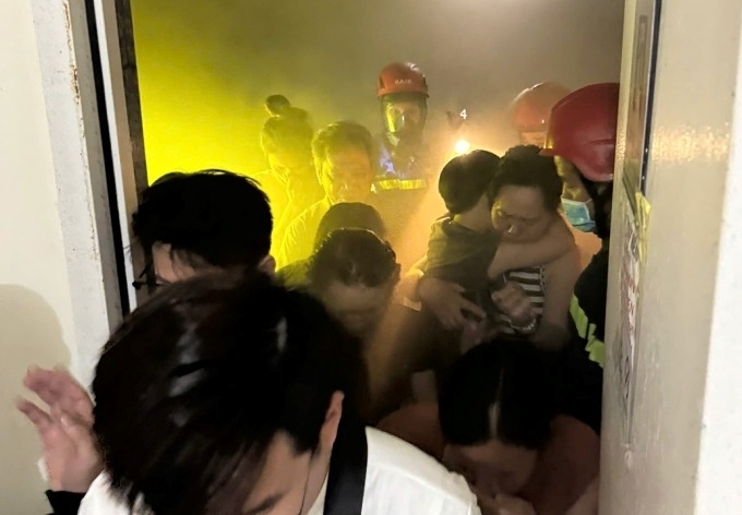 Cảnh sát sơ tán người dân thoát khỏi tầng có căn hộ cháy. Ảnh: VnExpress