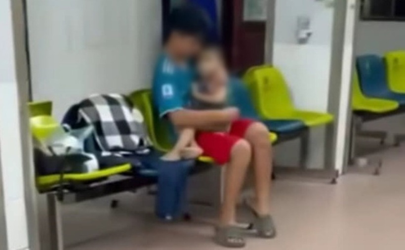 Cháu bé ở ngoài hành lang đợi cấp cứu tại bệnh viện. Ảnh: Cắt từ clip.