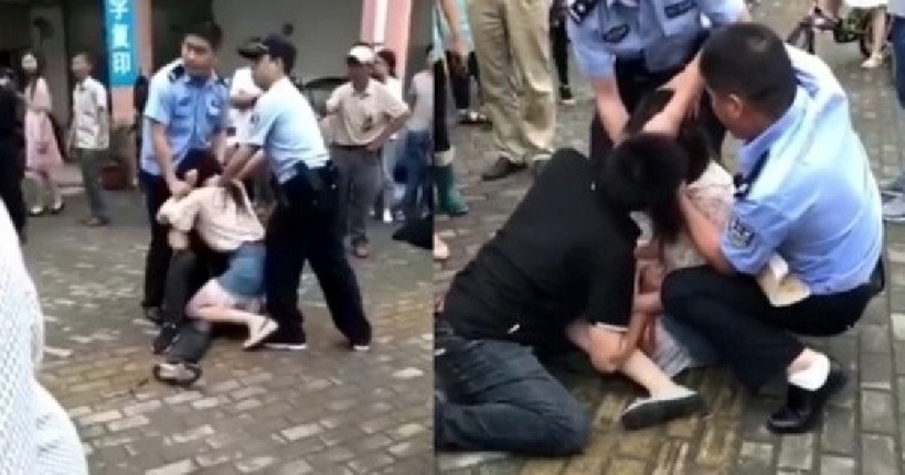 Cảnh sát quyết định xịt hơi cay để ép cô gái phải buông người yêu ra. Ảnh: Shanghaiist.
