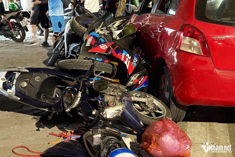 Tại hiện trường, các xe máy nằm la liệt trước đầu ô tô gây tai nạn.