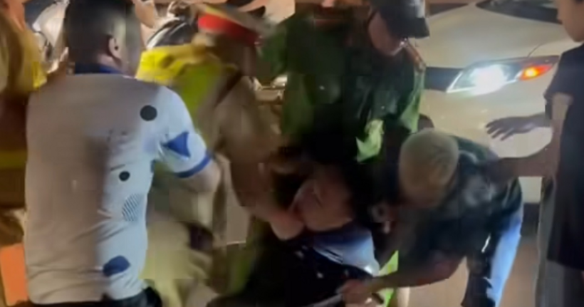 Hình ảnh cảnh sát khống chế người đàn ông mặc áo đen. (Ảnh: Chụp từ clip)