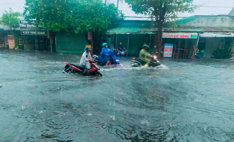 Nhiều người đi xe máy phải dắt bộ vì mưa lớn khiến đường ngập tại TP.Dĩ An, tỉnh Bình Dương. (Ảnh: Đại biểu nhân dân)