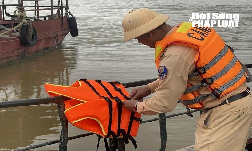 Lực lượng CSGT hướng dẫn cài áo phao đúng cách.